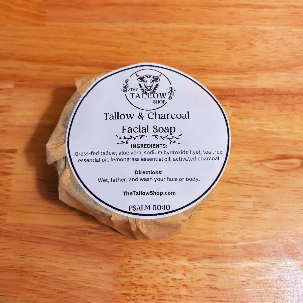 a wrapped bar of round soap on a wood block